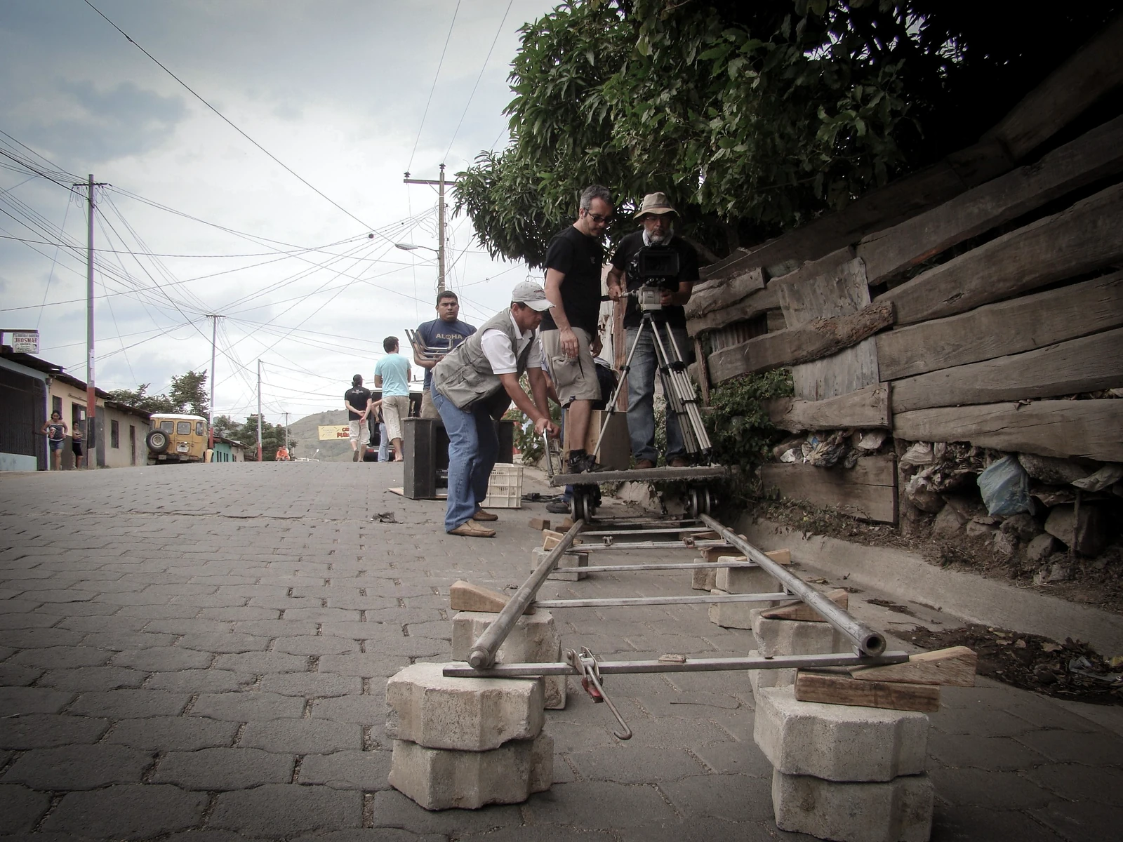 Equipo preparando la cámara y el travelling sobre una calle adoquinada