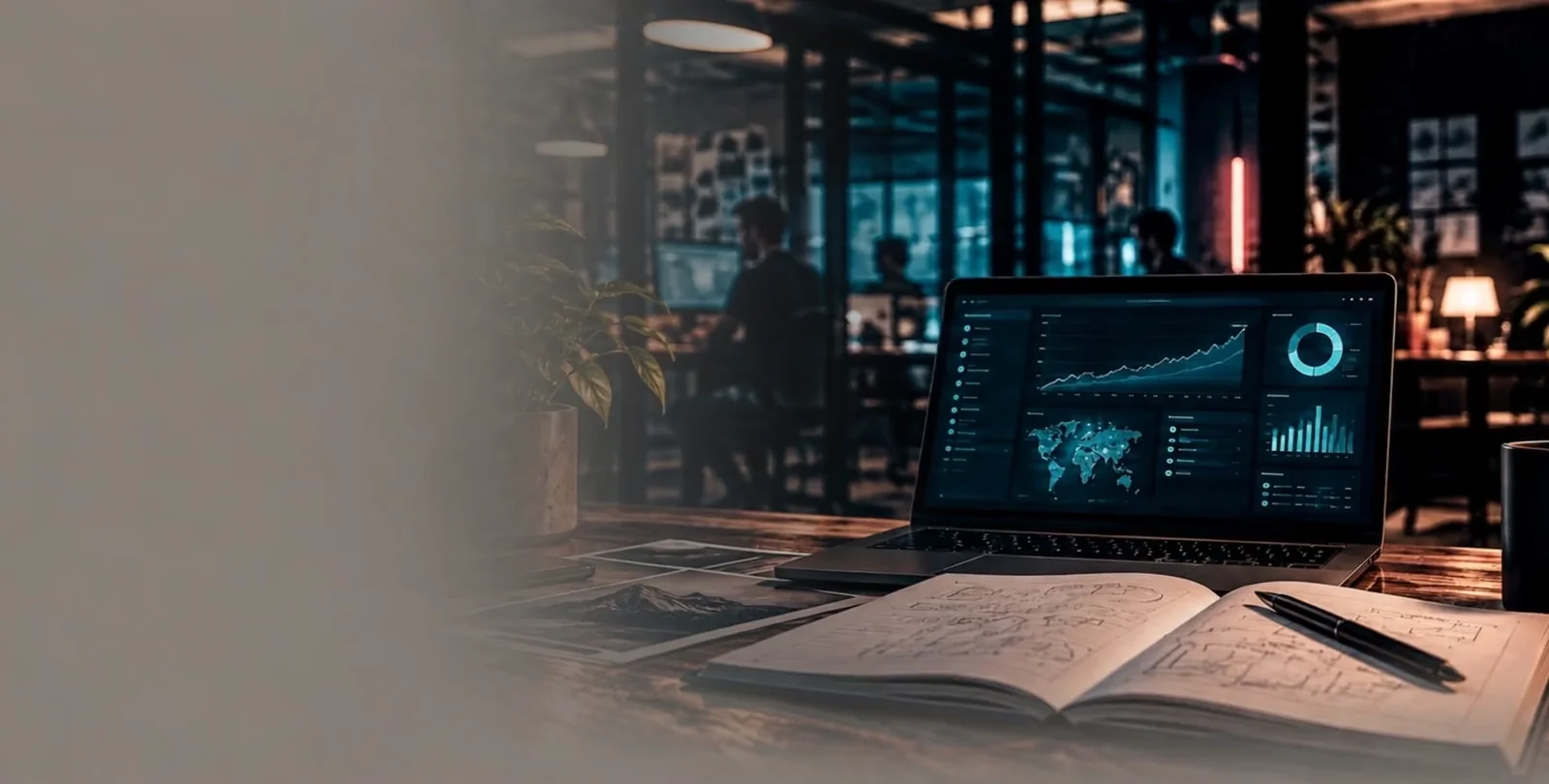 Laptop con dashboard de analytics y cuaderno de bocetos sobre un escritorio